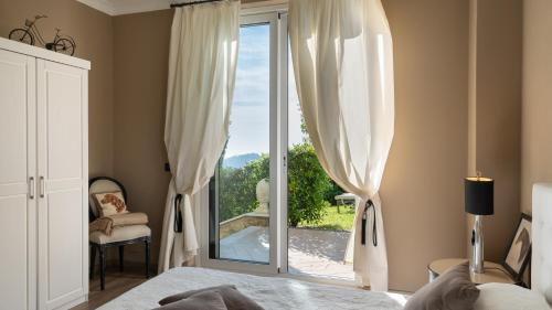 马萨罗萨Villa Dolphin 10, Emma Villas的一间卧室设有一张床和一个滑动玻璃门