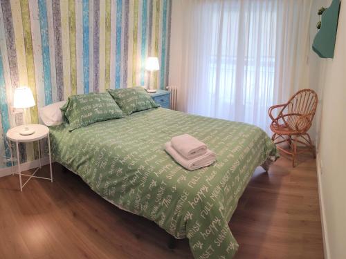 圣地亚哥－德孔波斯特拉CARMELA的一间卧室配有一张带绿色棉被的床