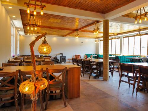 DemirciKanyon park otel ve restaurant的用餐室配有木桌和椅子