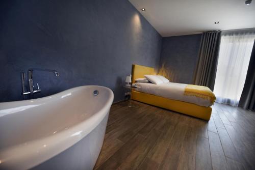 休吉让Quaint Boutique Hotel Xewkija的一间带浴缸的浴室和一张位于客房内的床