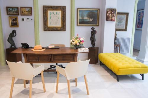安度亚尔Hotel Oleum - Parking Gratuito Reserva Previa的客房设有书桌和黄色长凳