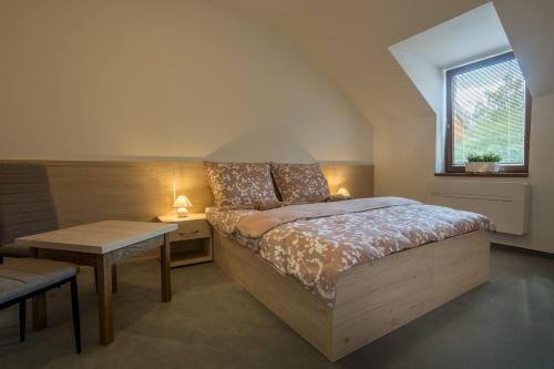 泰普拉Hotel U Nádraží的一间卧室配有一张床、一张桌子和一个窗户。