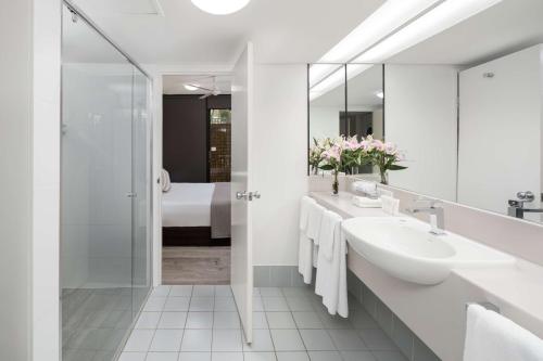 凯恩斯凯恩斯雷吉斯海滨大道度假酒店的白色的浴室设有水槽和淋浴。