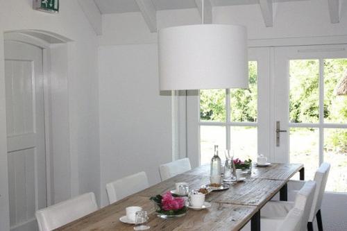 OosterwoldeB&B Buitenplaats Natuurlijk Goed的餐桌、白色椅子和大灯