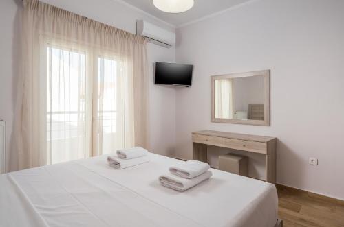 ArónionVilla ARONIOS的白色卧室配有床和镜子