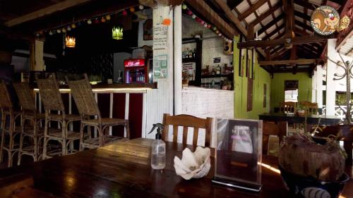 白马市Kep Melting Potes的一间带木桌和椅子的餐厅和一间酒吧