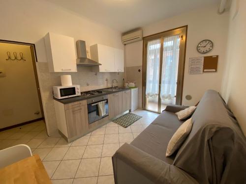 马格拉Little and cozy flat near Venice的带沙发的客厅和厨房