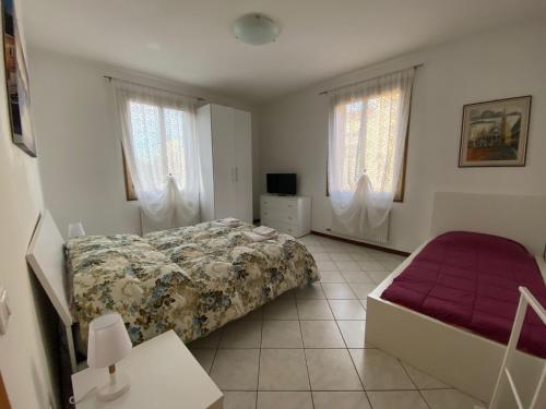 马格拉Little and cozy flat near Venice的一间卧室配有一张床、一张沙发和窗户。
