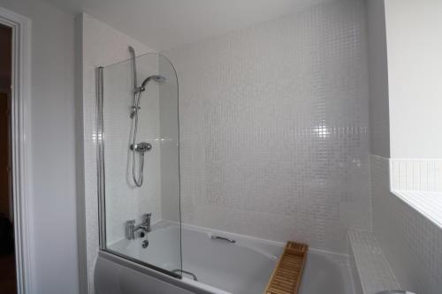 德比Millplace Apartments Derby的白色的浴室设有浴缸和淋浴。