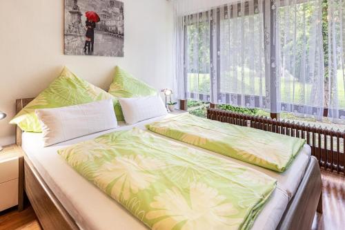 赖兴瑙Ferienwohnung Fetscher 1的一间卧室配有一张带绿色和白色床单的床