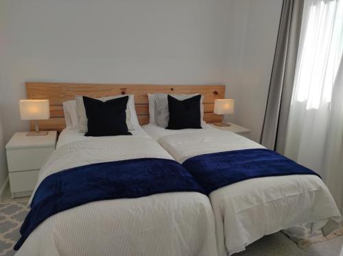 埃尔帕索CRÁTER 2的一张配有蓝色和白色床单及枕头的大床
