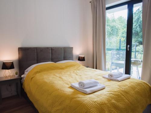 乌斯特龙Apartament Nad Strumykiem z ogródkiem - Dream Apart的一间卧室配有黄色的床和毛巾