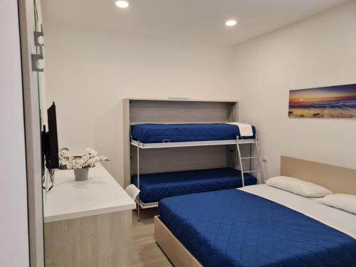 福尔米亚B&B Rayl的一间卧室配有两张双层床,铺有蓝色床单。