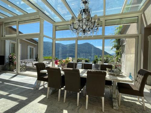 布里萨戈Brissago: Villa Claudia的一间带桌椅和玻璃天花板的用餐室