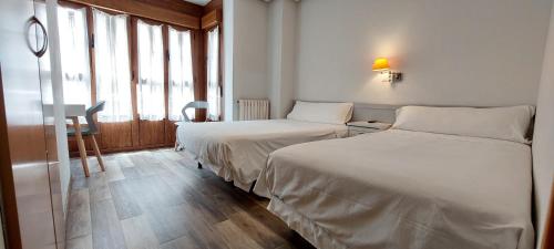奥维多罗梅罗旅馆的酒店客房设有两张床和窗户。