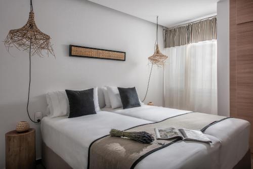 赫索尼索斯Khroma Luxury Suite 2 Beach front apartment的白色墙壁客房的两张床