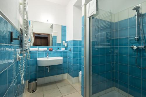 比得哥什斯洛泽尼马林酒店的蓝色瓷砖浴室设有水槽和淋浴