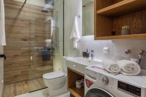 海若克利欧Athena Apartment的一间带洗衣机和水槽的浴室