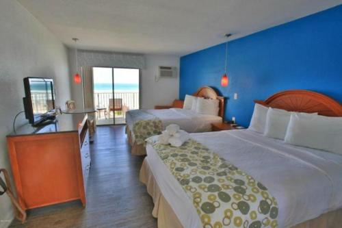 代托纳海滩Daytona Dream Inn By AmeriVu的酒店客房设有两张床和电视。