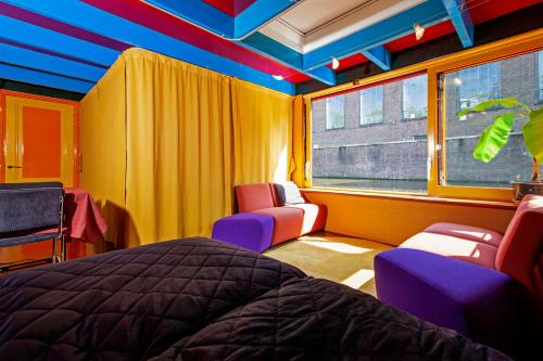 阿姆斯特丹Dreamtime Houseboat的一间卧室配有床、椅子和窗户