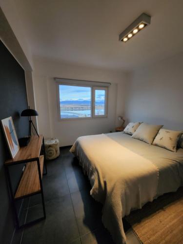乌斯怀亚LiveUshuaia Beagle View Apartmento 2 dormitorios的一间卧室设有一张大床和一个窗户。