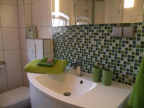 克鲁姆赫恩Apartment Vier Jahreszeiten Pilsum的一间带水槽和绿毛巾的浴室