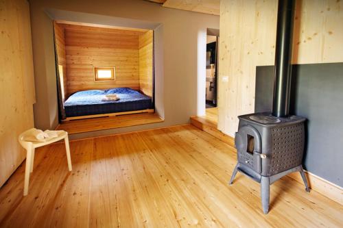 帕卢扎La Marmote Albergo Diffuso di Paluzza Faas的一间卧室配有一张床和一个燃木炉子