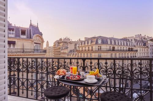 巴黎Grand Powers Hotel的阳台上桌子上的托盘食物