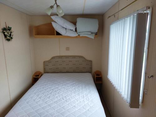 斯凯格内斯6 berth static caravan, sealands holiday park ingoldmells, skegness的一间小卧室,配有床和窗户