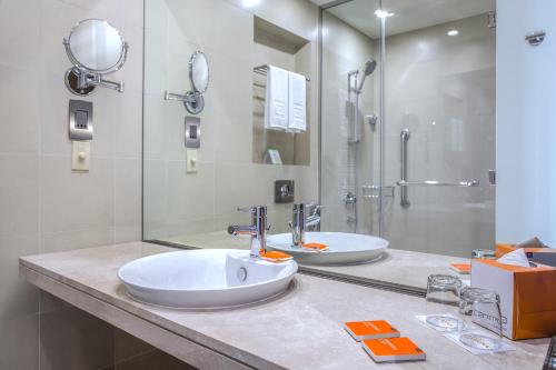 沙迦Centro Sharjah的一间带两个盥洗盆和淋浴的浴室
