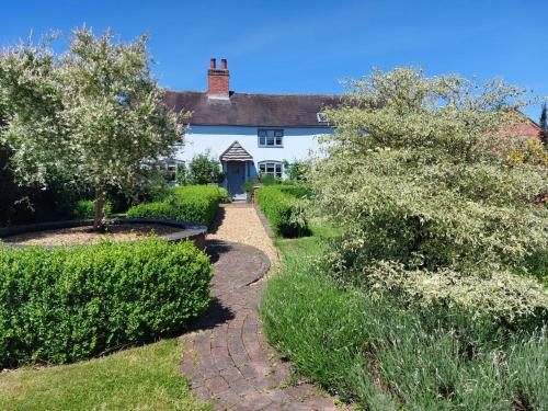 利奇菲尔德Beautiful 3 Bedroom Cottage - Picturesque Retreat的一座带花园和走道的房子