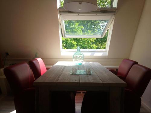 奈梅亨德格菲特住宿加早餐旅馆的一张桌子,上面有红色的椅子和玻璃瓶