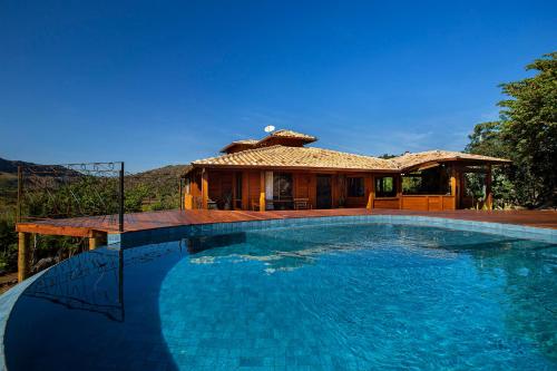 圣安娜杜里亚舒Sitio Jatoba/Lapinha da Serra的房屋前的大型游泳池