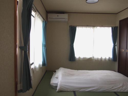 Haru, - Vacation STAY 66521v的一间卧室设有一张床和两个窗户。