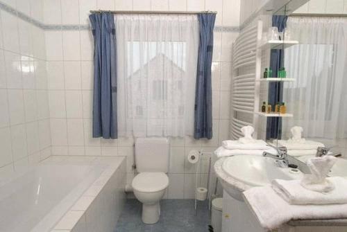 马尔梅迪Le Bernister parking privé的白色的浴室设有浴缸、卫生间和水槽。