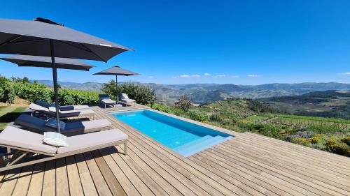 ProvesendeCasa de Pena d'Águia - Douro Encantado的一座带游泳池和遮阳伞的别墅
