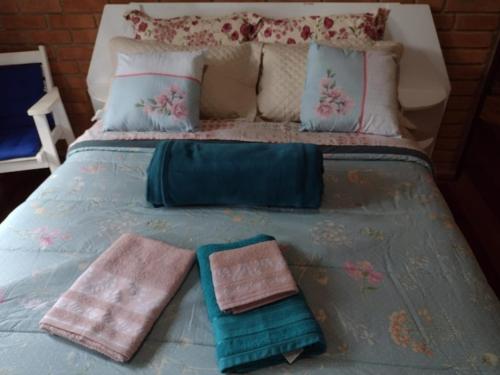 贡萨尔维斯Casa de Campo Meu Pequeno Paraíso的床上有两条毛巾