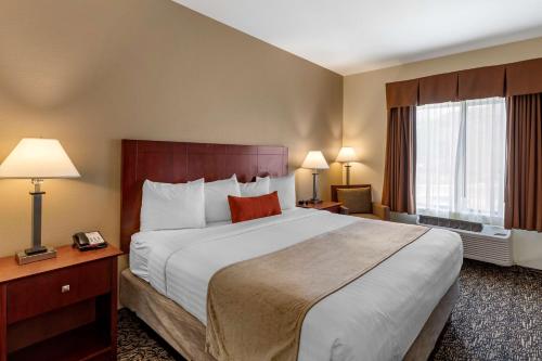 路易维尔Best Western Plus Boulder Louisville的酒店客房设有一张大床和两个窗户。