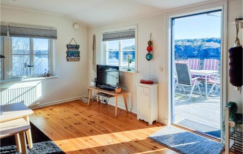 HenånAmazing Home In Henn With House Sea View的一间带电视和滑动玻璃门的客厅