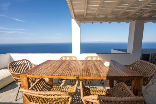 阿提蒙Astarte Luxury Apartments的阳台上的木桌和椅子