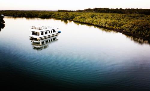 黄金海岸Coomera Houseboats的坐在河水中的船