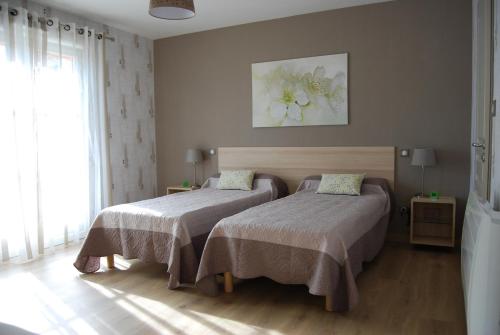 Créney-près-Troyes梅内格度假屋的一间卧室设有两张床和窗户。