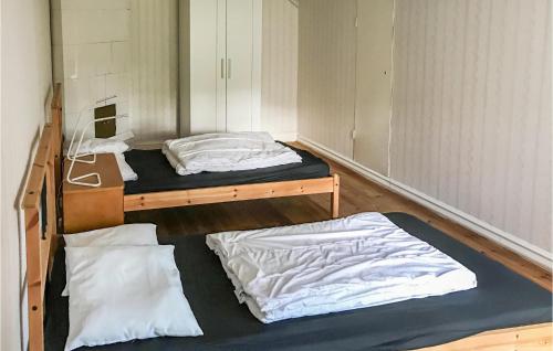 Skärblacka2 Bedroom Lovely Home In Kimstad的客房设有两张床和一张书桌。