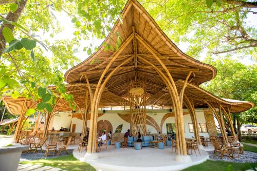 塞隆贝拉纳克Tropik Resort Lombok的一个带桌椅的大型木制凉亭