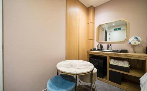 釜山Bay 202 Hotel的浴室设有桌子、水槽和镜子