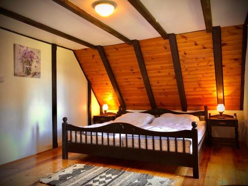 弗林布尔克Chata Klára的一间带一张床的卧室,位于带木制天花板的房间内