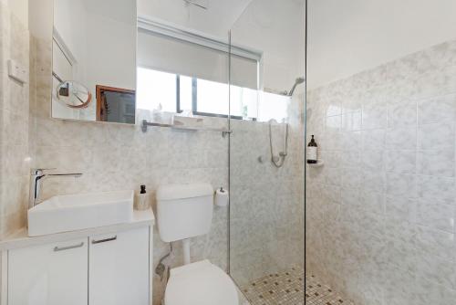 麦夸里港Fi's Beach Pad的一间带卫生间和玻璃淋浴间的浴室