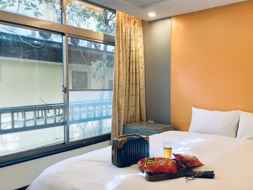 台北水都溫泉會館 的酒店客房设有一张带窗户的床。