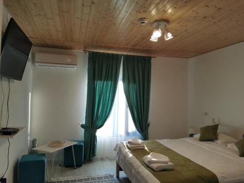 MaliucDelta Blue的一间卧室设有床铺和一个带绿色窗帘的窗户。