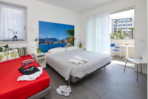 加尔达湖滨Casa al Lago的一间卧室配有两张床和一张红色沙发
